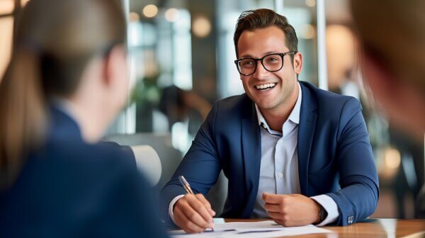 Man sitting at table across from woman talking about stability in firm transitions